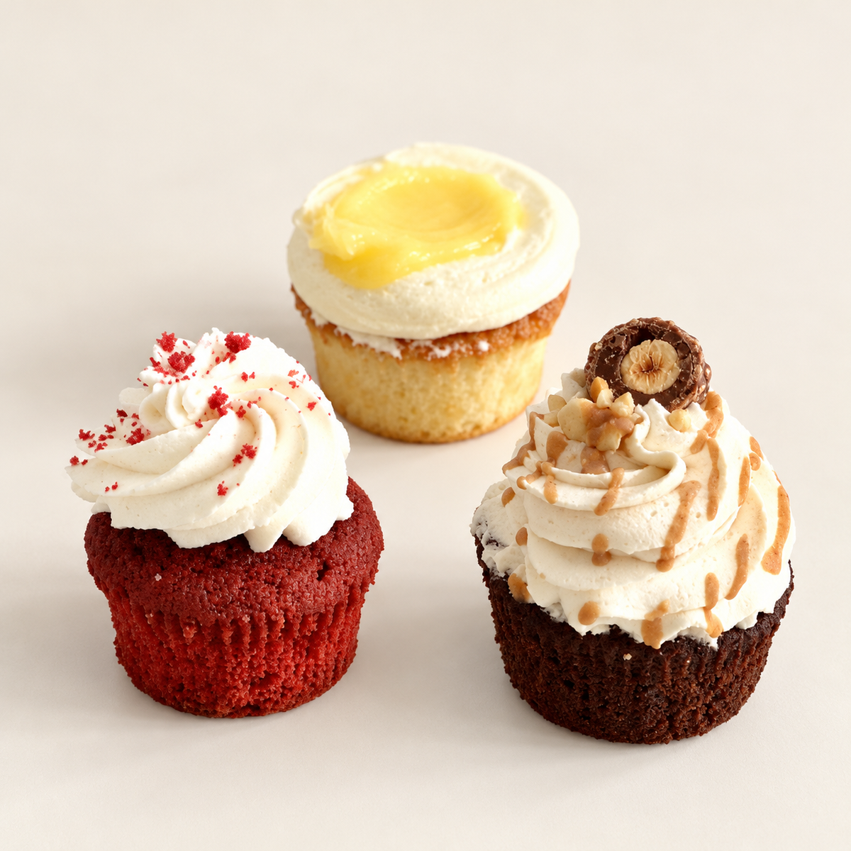 Assortiments Cupcakes (Choix du chef) sur fond ivoire, composition de trois cupcakes